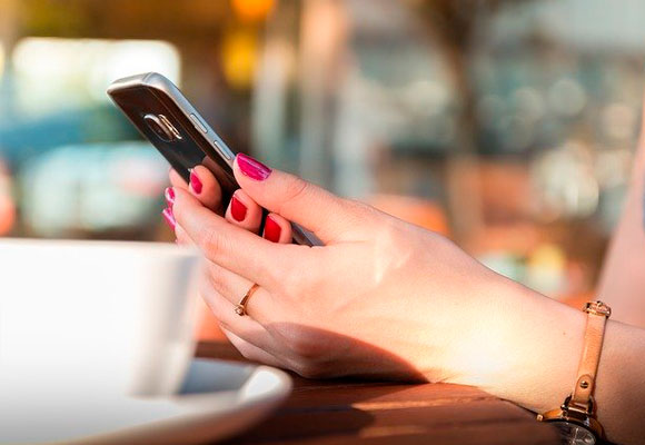 mujer uñas teléfono